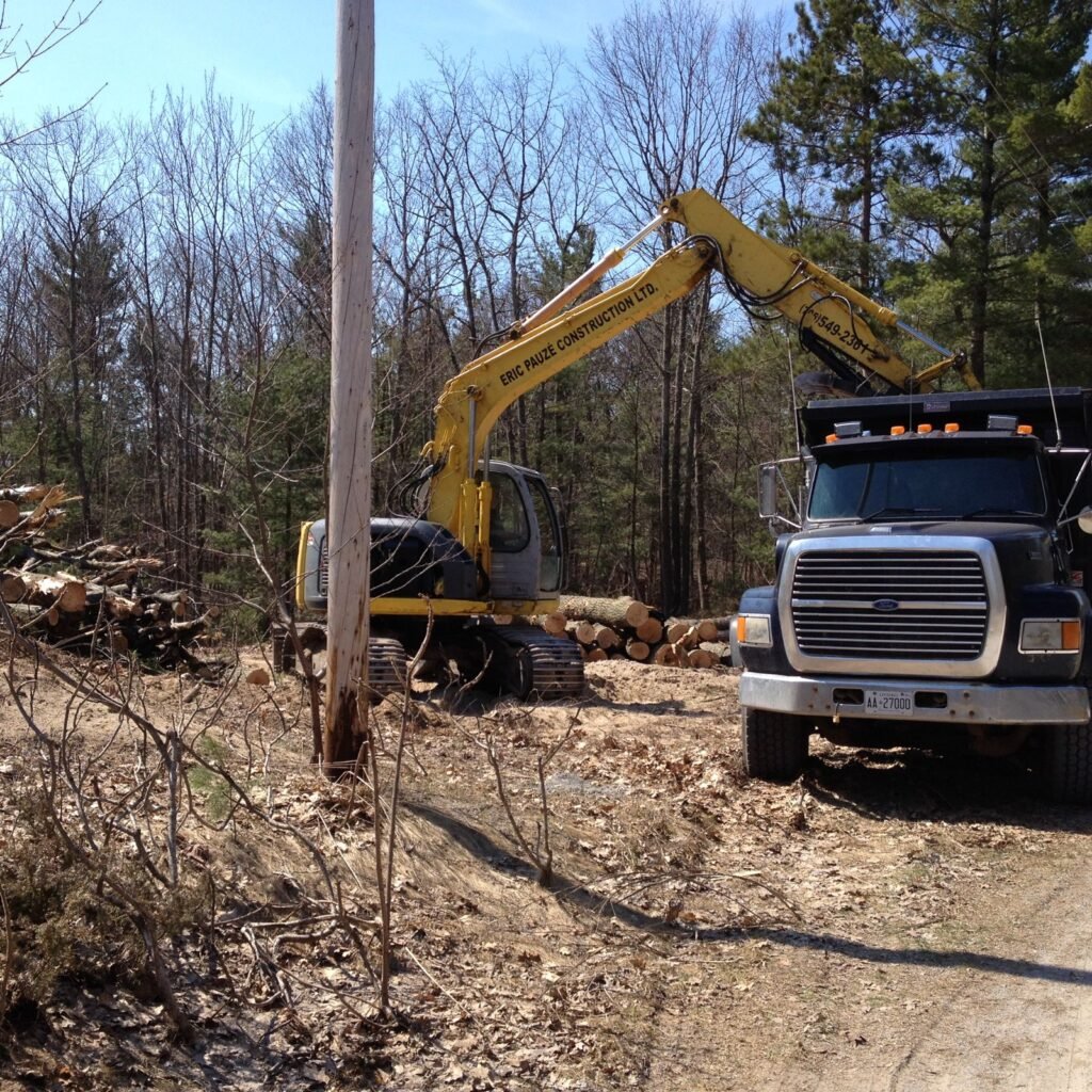 Excavator and dump truck preparing a building site in Simcoe County