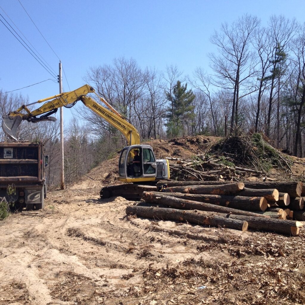 Excavator sorting logs during lot clearing